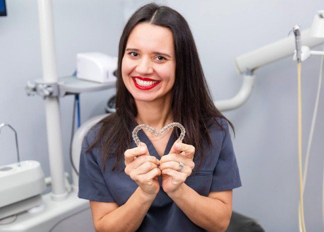 Dr. Nadia Rodriguez holding clear aligners